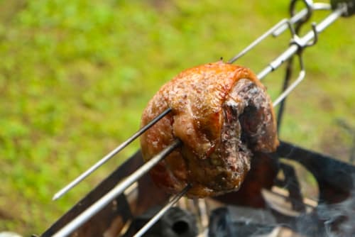 バーベキューで豚肉の塊の串焼き