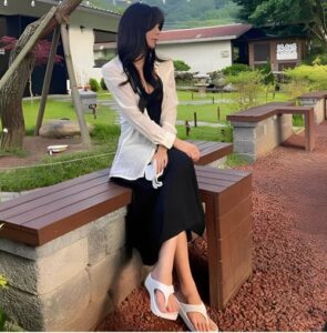サンダルを履いた公園に座る女性