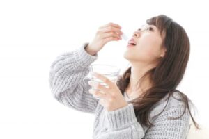 粉薬を飲む女性